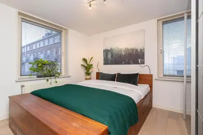 a bedroom with a bed with a green blanket at Zaan City Deck in Zaandam
