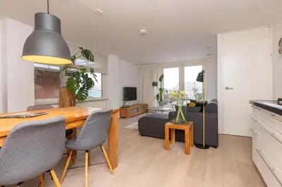 a dining room and living room with a table and chairs at Zaan City Deck in Zaandam