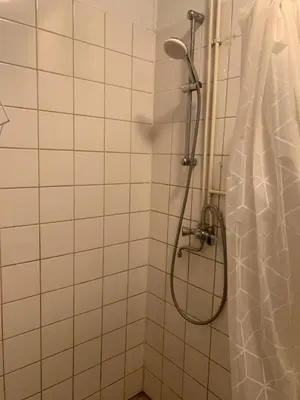 a shower in a white tiled bathroom with a shower curtain at Connected comfort in Amsterdam