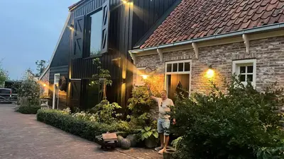 a man standing in front of a house at B&B De Wilgenhoeve in Kwadijk