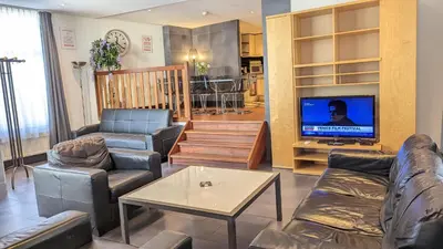 a living room with couches and a flat screen tv at The Amsterdam Hotel Apartment in the Center in Amsterdam