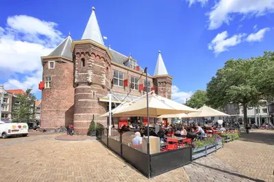 a group of people sitting at tables in front of a building at The Amsterdam Hotel Apartment in the Center in Amsterdam
