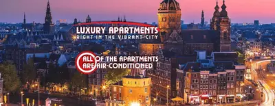 a view of a city at night with a sign at The Amsterdam Hotel Apartment in the Center in Amsterdam