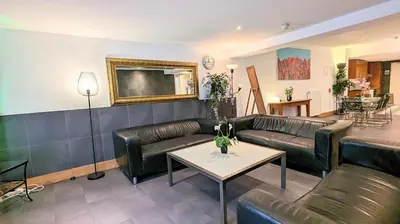 a living room with leather couches and a table at The Amsterdam Hotel Apartment in the Center in Amsterdam
