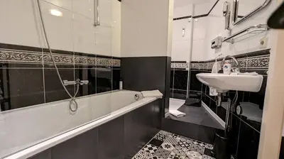a bathroom with a bath tub and a sink at The Amsterdam Hotel Apartment in the Center in Amsterdam