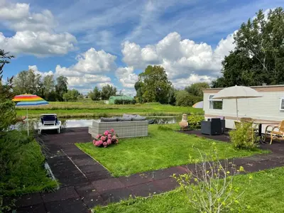 a backyard with a couch and an umbrella at Houseboatvinkeveen Lelie in Vinkeveen