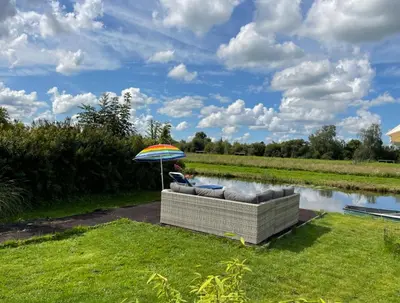 a person sitting on a couch under an umbrella at Houseboatvinkeveen Lelie in Vinkeveen