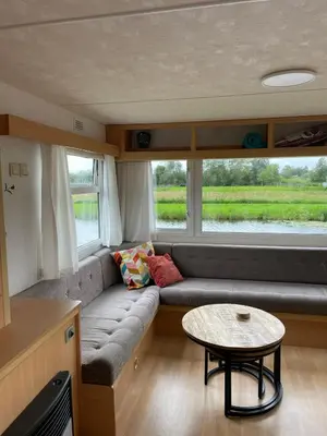a living room with a couch and a table at Houseboatvinkeveen Lelie in Vinkeveen