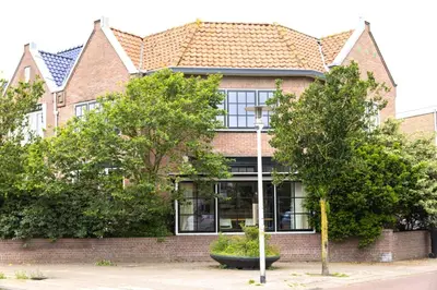 a brick house with trees in front of it at Zandhuys in Zandvoort