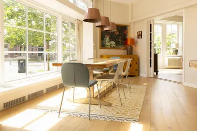 a dining room with a table and chairs and a window at Zandhuys in Zandvoort