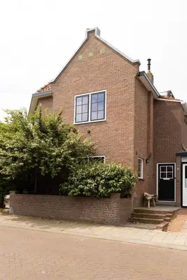 a brick house with a bench in front of it at Zandhuys in Zandvoort
