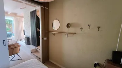 a bedroom with a bed and a mirror on the wall at Vakantiehuis Lycka in Noordwijkerhout