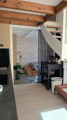 a living room with a staircase and a couch at Vakantiehuis Lycka in Noordwijkerhout