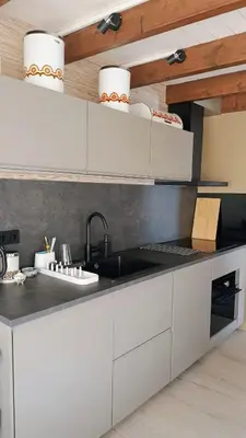 a kitchen with white cabinets and a sink at Vakantiehuis Lycka in Noordwijkerhout