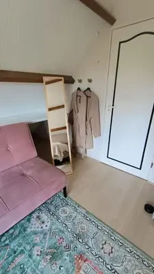 a bedroom with a pink bed and a closet at Vakantiehuis Lycka in Noordwijkerhout