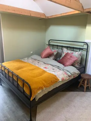 a bed with a metal frame and red pillows at Little Betsy in Zandvoort