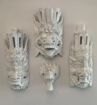 a group of white masks hanging on a wall at Little Betsy in Zandvoort