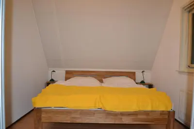 a bedroom with a bed with a yellow blanket at Ankes Traumhaus in Sint Maarten