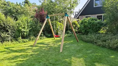 a swing set in the grass in a yard at Ankes Traumhaus in Sint Maarten