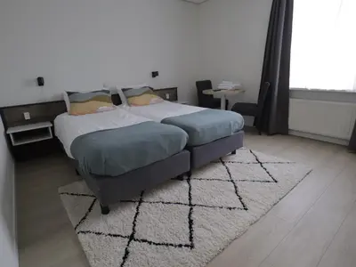 a bedroom with a bed and a rug in a room at Hotel Zuideinde in Nieuwkoop