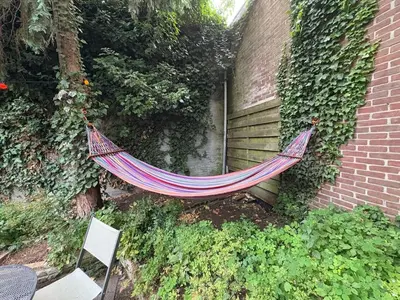 a hammock hanging from the side of a building at Cozy two-room city center apartment with garden in Amersfoort