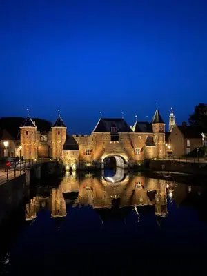 an old castle with a reflection in the water at night at Cozy two-room city center apartment with garden in Amersfoort