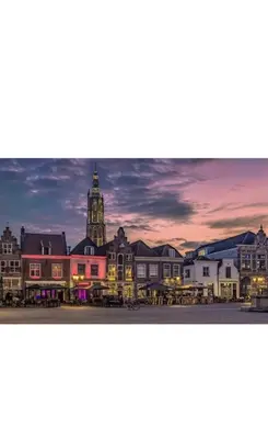 a view of a town with a clock tower at dusk at Cozy two-room city center apartment with garden in Amersfoort