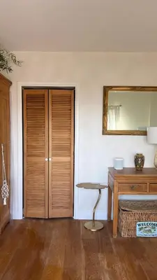a room with a wooden door and a mirror at Little Paradise in Zandvoort