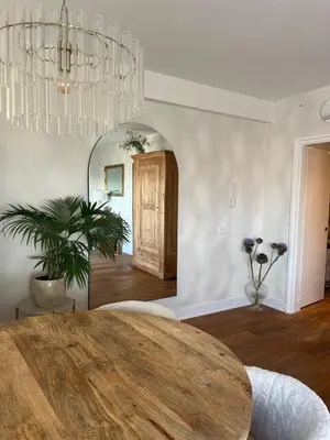 a dining room with a wooden table and a chandelier at Little Paradise in Zandvoort