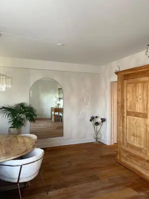 a living room with a table and a mirror at Little Paradise in Zandvoort