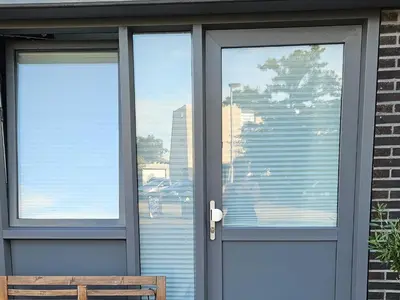 a glass door with a view of a building at Studio Spring - 20 min from Amsterdam Centre - FREE parking in Purmerend