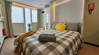 a bedroom with a bed with a checkered blanket at Studio Spring - 20 min from Amsterdam Centre - FREE parking in Purmerend