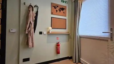 a room with a door and a fire extinguisher on the wall at Studio Spring - 20 min from Amsterdam Centre - FREE parking in Purmerend