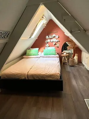 a bedroom with a large bed in a attic at Tiny House - Surfers Paradise in Noordwijk