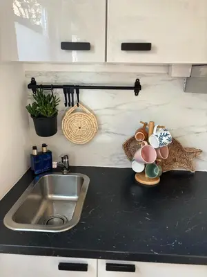 a kitchen counter with a sink and some dishes on it at Tiny House - Surfers Paradise in Noordwijk