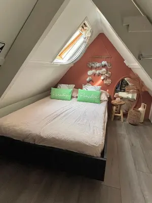 a bedroom with a bed in the attic at Tiny House - Surfers Paradise in Noordwijk
