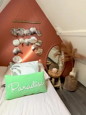 a bedroom with a bed with a pillow and a mirror at Tiny House - Surfers Paradise in Noordwijk