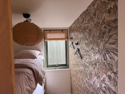 a bedroom with a bed and a window at 't Hoevehuisje in Beverwijk