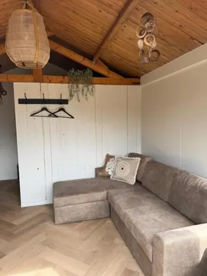 a living room with a couch and a ceiling at 't Hoevehuisje in Beverwijk