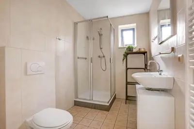 a bathroom with a shower and a toilet and a sink at Vakantiepark Schoorlse Duinen in Schoorl
