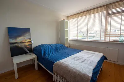a bedroom with a bed and a window at Huize Zonnebloem in Beverwijk