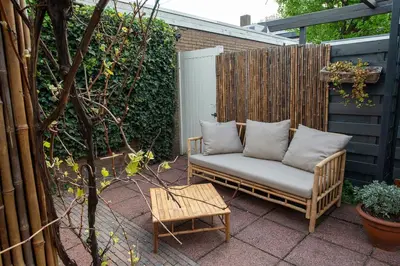 a patio with a couch with pillows on it at Huize Zonnebloem in Beverwijk