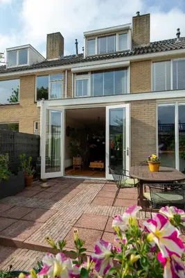 a house with sliding glass doors and a patio at Huize Zonnebloem in Beverwijk