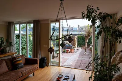 a living room with a couch and a large glass door at Huize Zonnebloem in Beverwijk