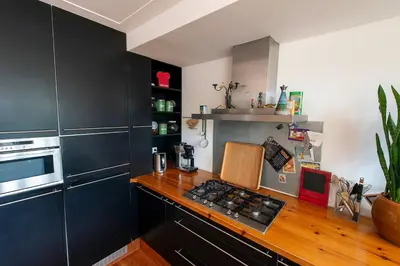 a kitchen with black cabinets and a counter top at Huize Zonnebloem in Beverwijk