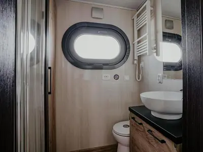 a small bathroom with a toilet and a sink at Houseboat at Marina with Lake Views in Uitgeest
