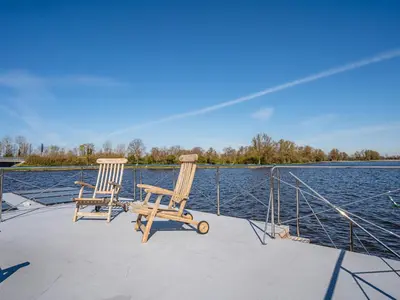 two chairs sitting on the back of a boat at Houseboat at Marina with Lake Views in Uitgeest