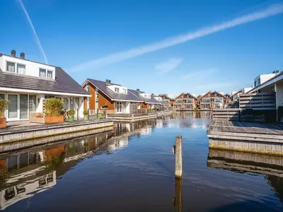 a row of houses and a canal with houses at Houseboat at Marina with Lake Views in Uitgeest