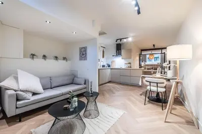 a living room with a couch and a kitchen at Central Luxury Apartment in Amsterdam