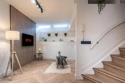 a staircase in a white room with a table at Central Luxury Apartment in Amsterdam